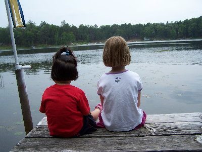 Sisters enjoying quiet moment by the water.